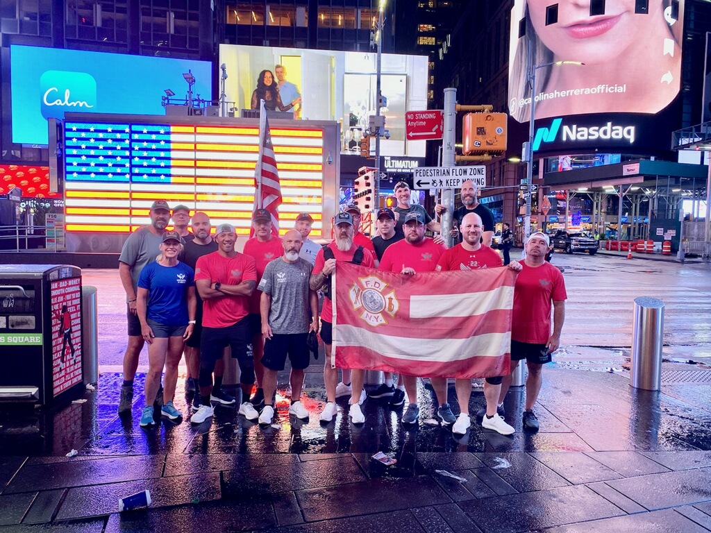 Shepherd's Men team in Times Square with an FDNY flag